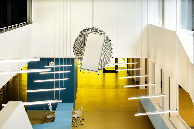 Installation aus mehreren Tischen an der Decke eines Schulgebäudes angebracht.