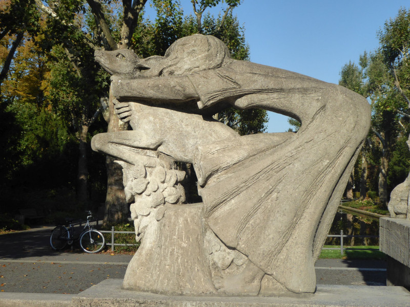 Skulptur einer Frau, die ein Tier umarmt