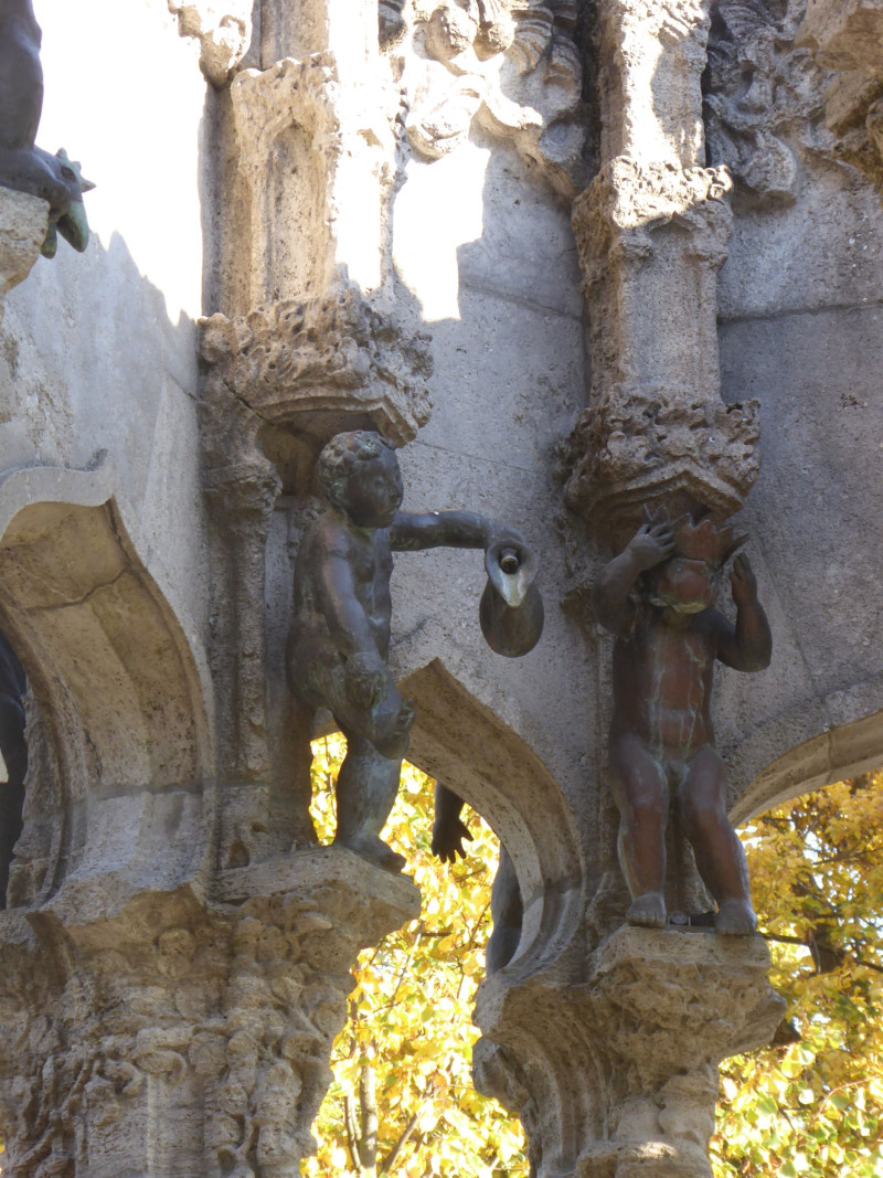 Zwei Skulpturfiguren, die in einen Brunnen integriert sind.