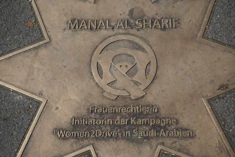 Gedenkplatte mit Metallporträt und Inschrift über eine Persönlichkeit im Boden eines Schulgebäudes eingelassen.