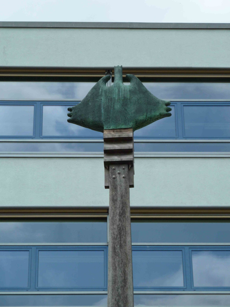 Detail von einer Skulptur vor einer Schule
