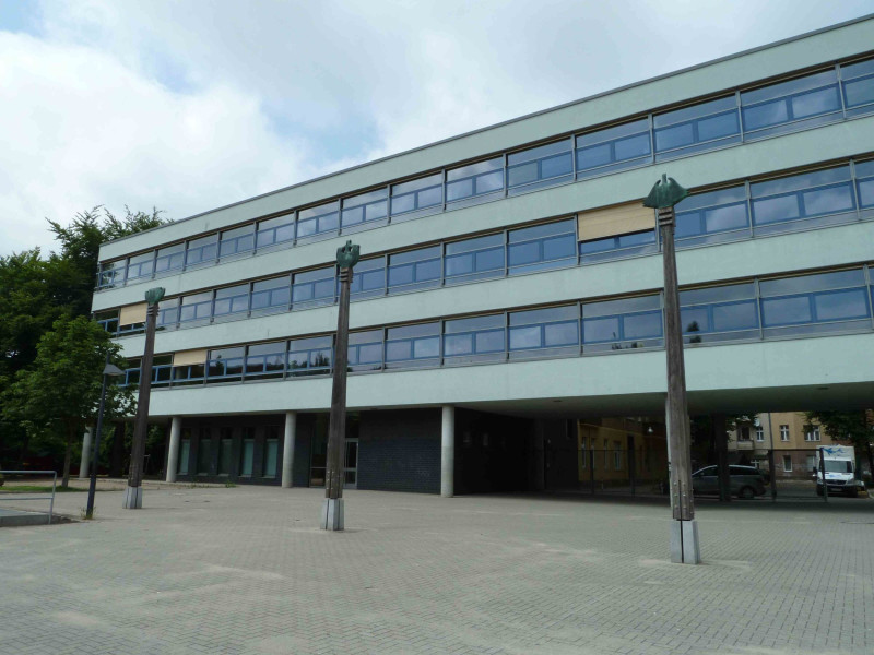 Drei Skulpturen vor einer Schulgebäude