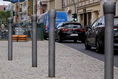 Großformatige Skulpturen in Form deformierter Nägel in der Mitte einer Straße.