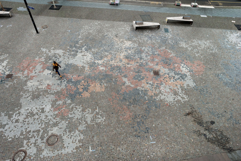 Passantin läuft über Kunst am Bau Werk.