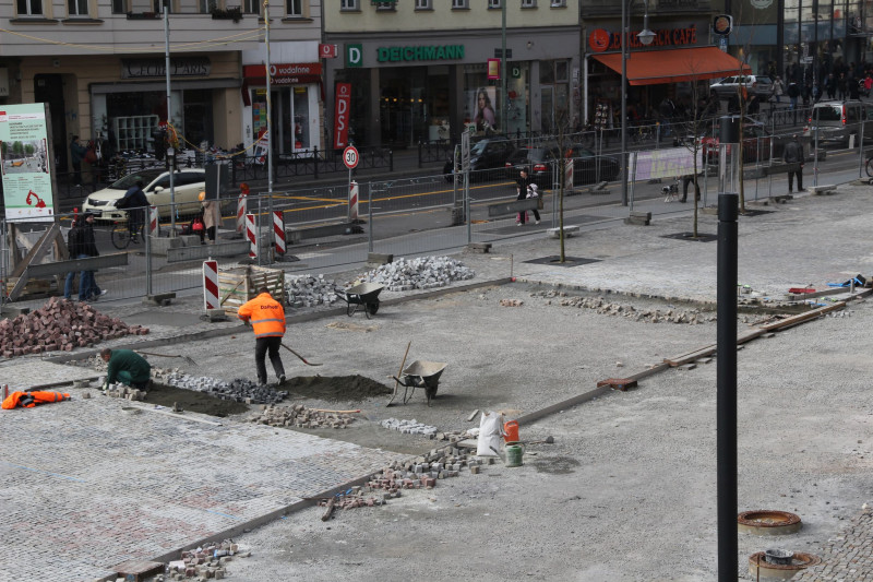 Zwei Bauarbeiter arbeiten an einem Boden am Alfred-Scholz-Platz