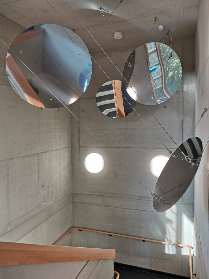 Kreisförmige Spiegel an der Treppenhausdecke einer Schule.