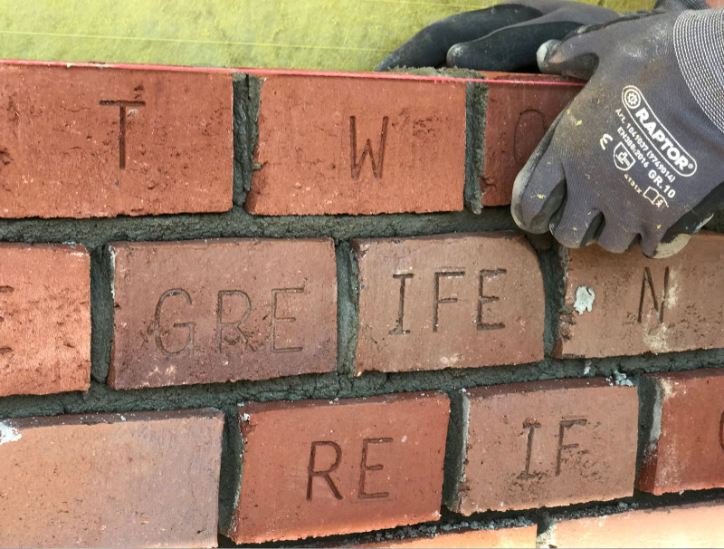 Ziegelsteine mit eingravierten Buchstaben