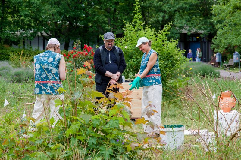 text: >
  Drei Personen erkunden die Installation
  „Depot / 52.425678, 13.460060
