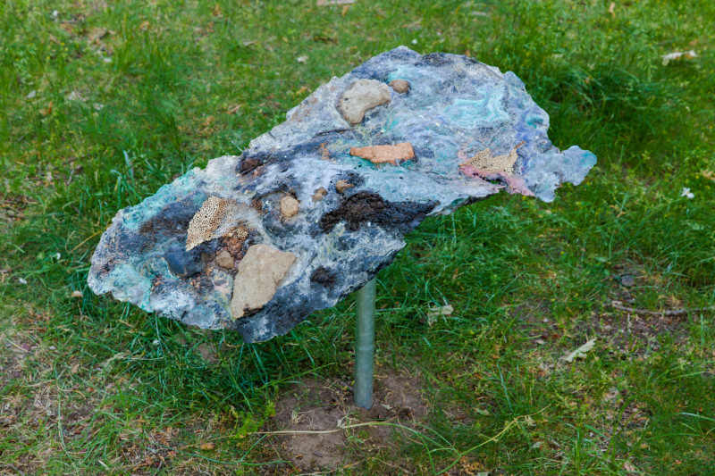 text: >
  Geologisches Fragment aus Silvia
  Noronhas Installation Shifting Geologies
  auf einem Pfahl in der Wiese
decorative: false
source: manual