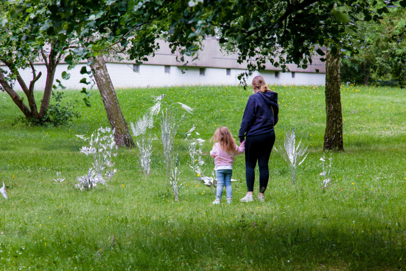 text: >
  Zwei Menschen erkunden die Installation
  „Aluminium Garden