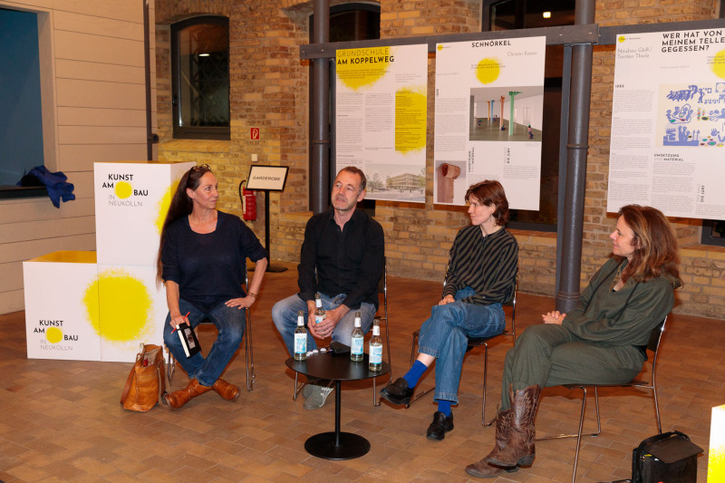 Vier Personen und Sprecher in einer Veranstaltung sitzen nebeneinander