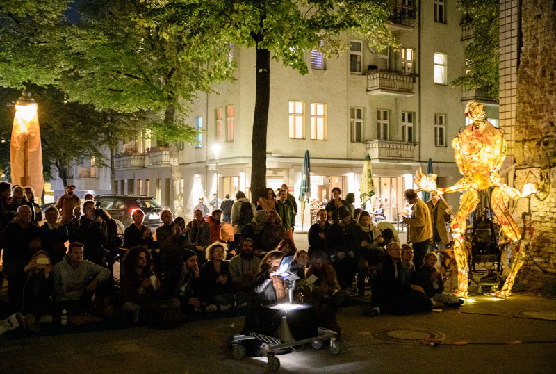 text: >
  Menschen auf der Straße bei einer
  Präsentation mit gemütlichem Licht
decorative: false
source: manual