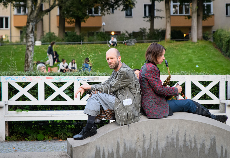 text: 'Zwei Künstler*innen sitzen im Körnerpark mit einer Musikinstrument'
decorative: false
source: manual