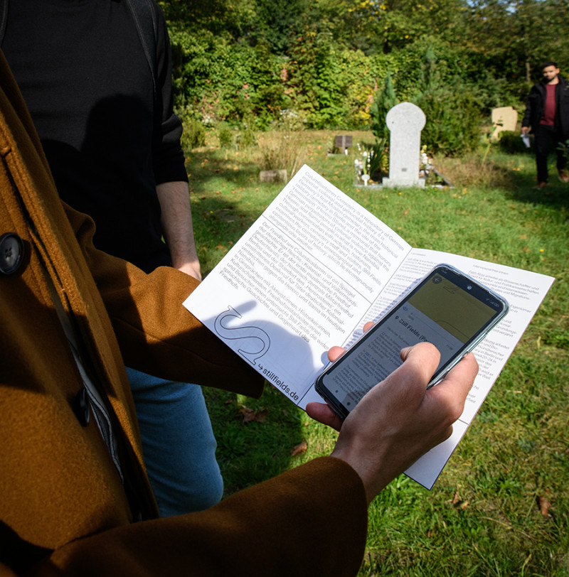 text: >
  Person liest ein Begleitprogramm auf
  Papier mit Hilfe eines Handys
decorative: false
source: manual